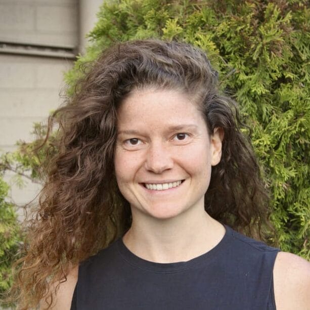 Alexandra Hill smiling and standing in front of greenery