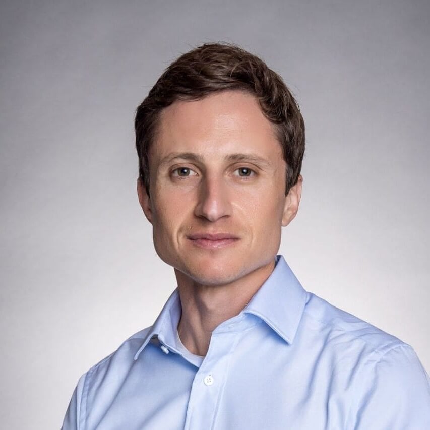 Chris Lowenstein posing formally in a button-up shirt
